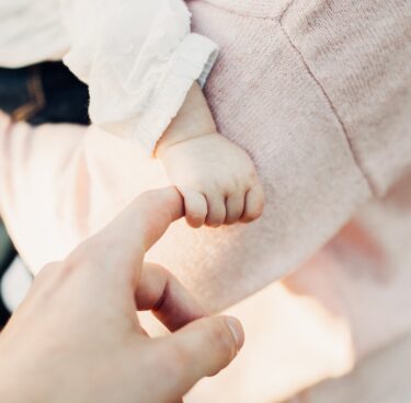 Bébé dans les bras de sa maman lors d'un baptême à Lyon